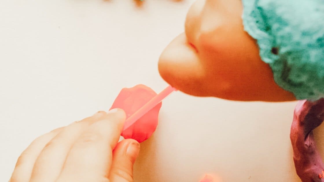child cutting play dough
