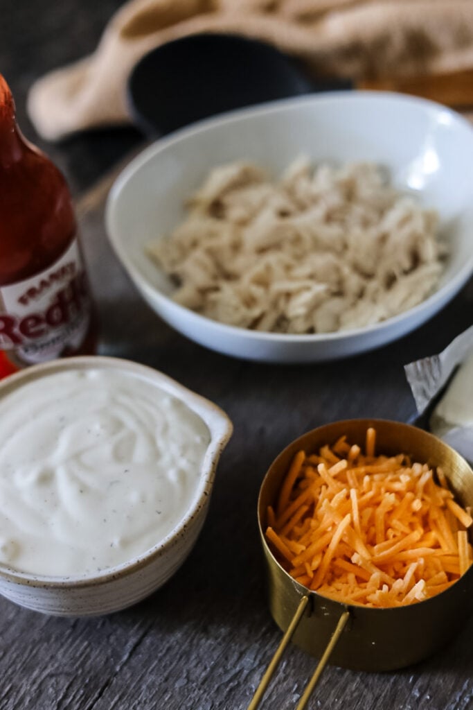 chicken, cheese, and ranch dressing measured for a buffalo chicken dip recipe