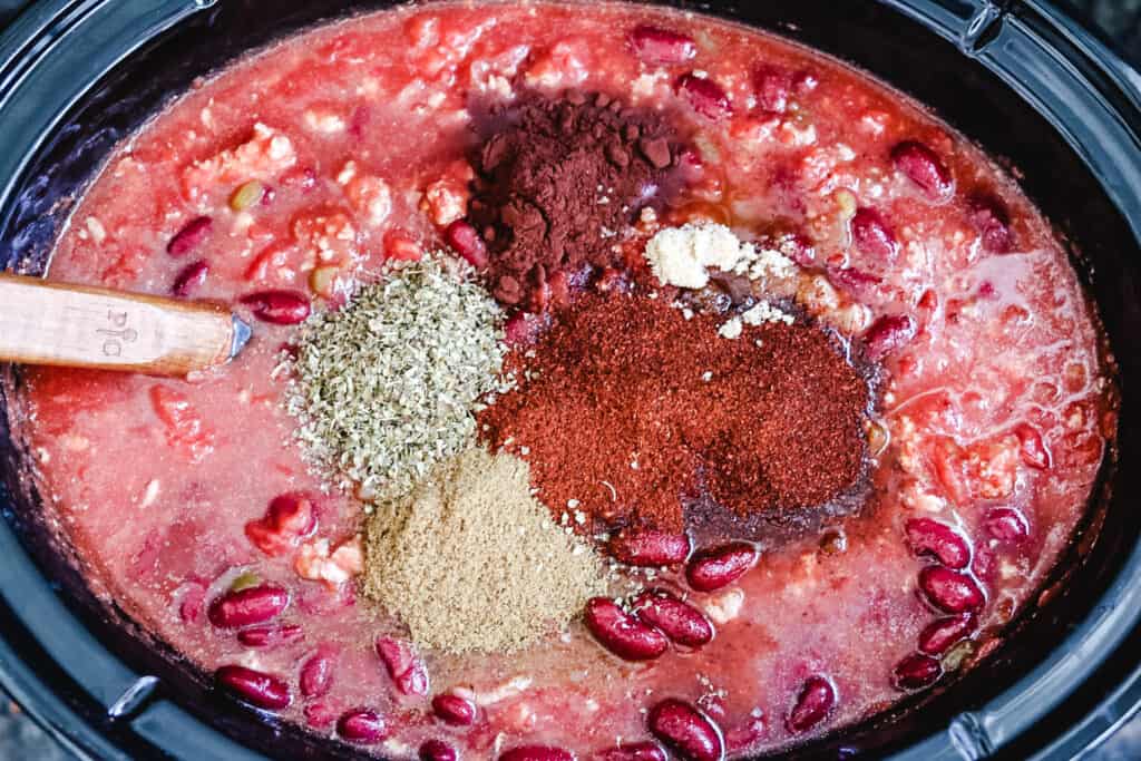 adding spices to chili