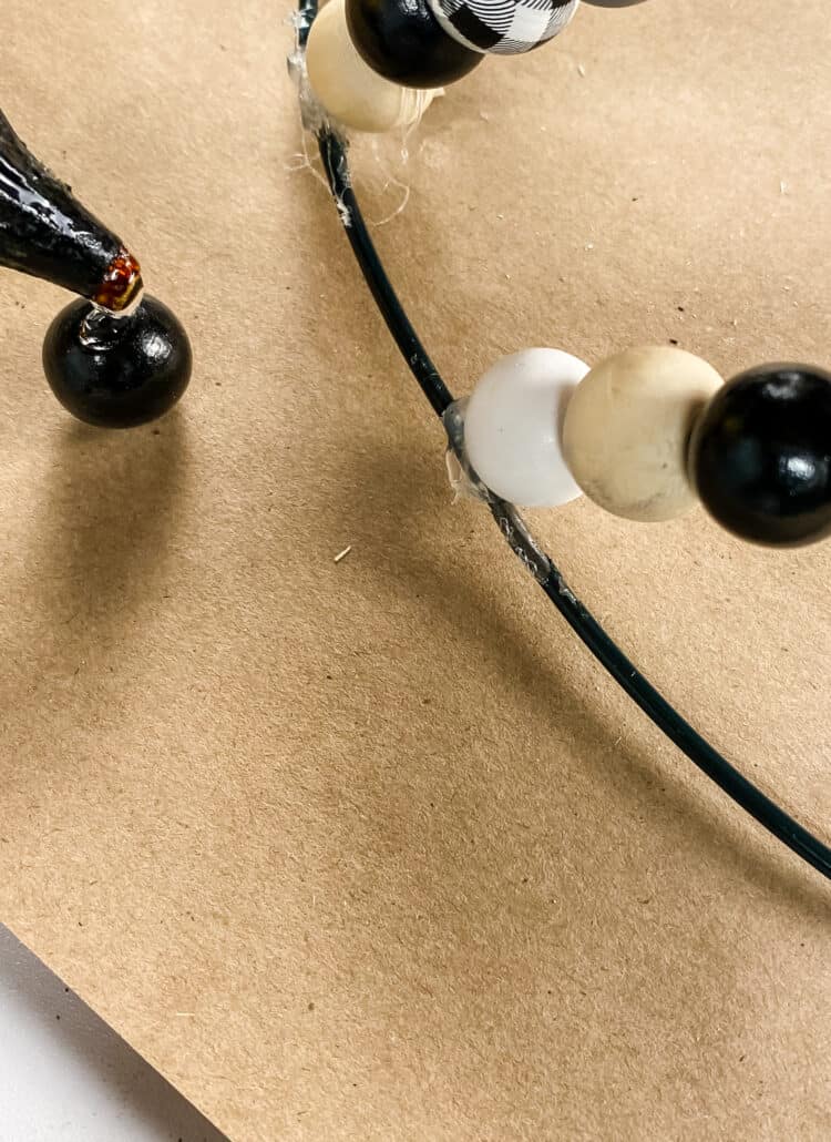 hot gluing a wood bead in place