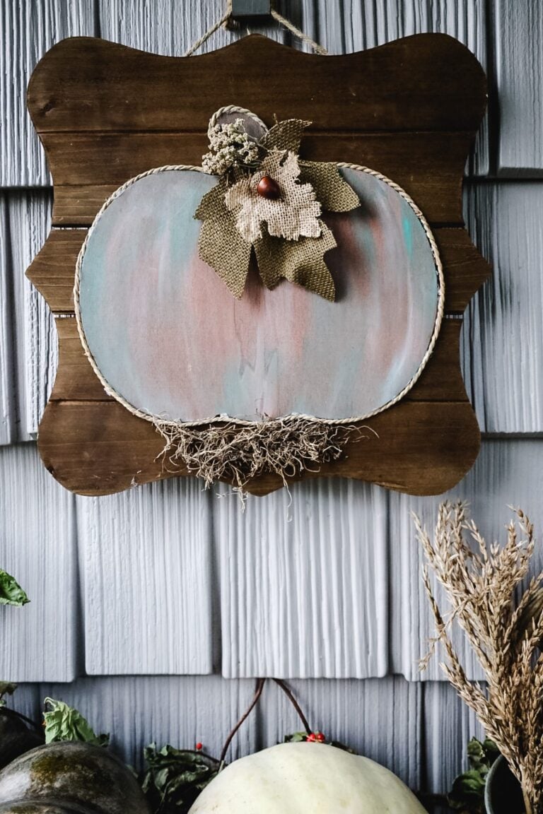 Wood pumpkin sign hanging on house