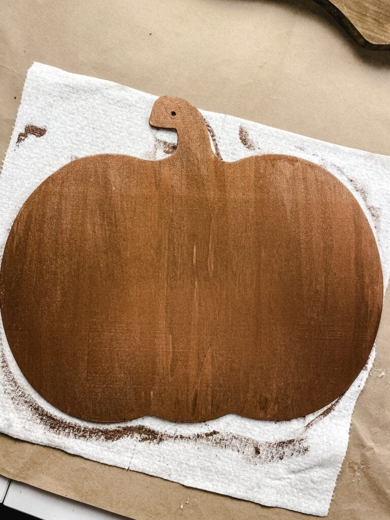 painting a pumpkin sign with copper paint