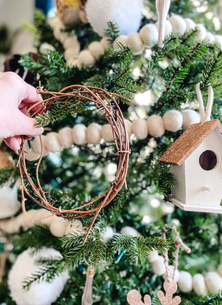 adding mini grapevine wreath to a Christmas tree