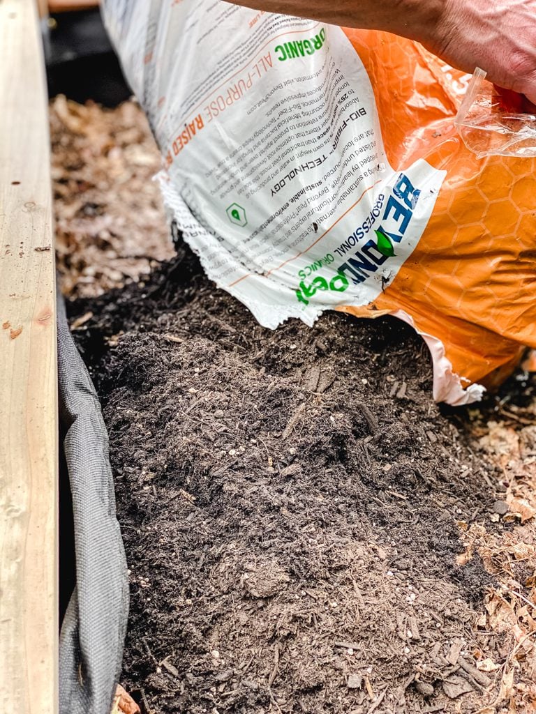 dumping soil into a raised bed