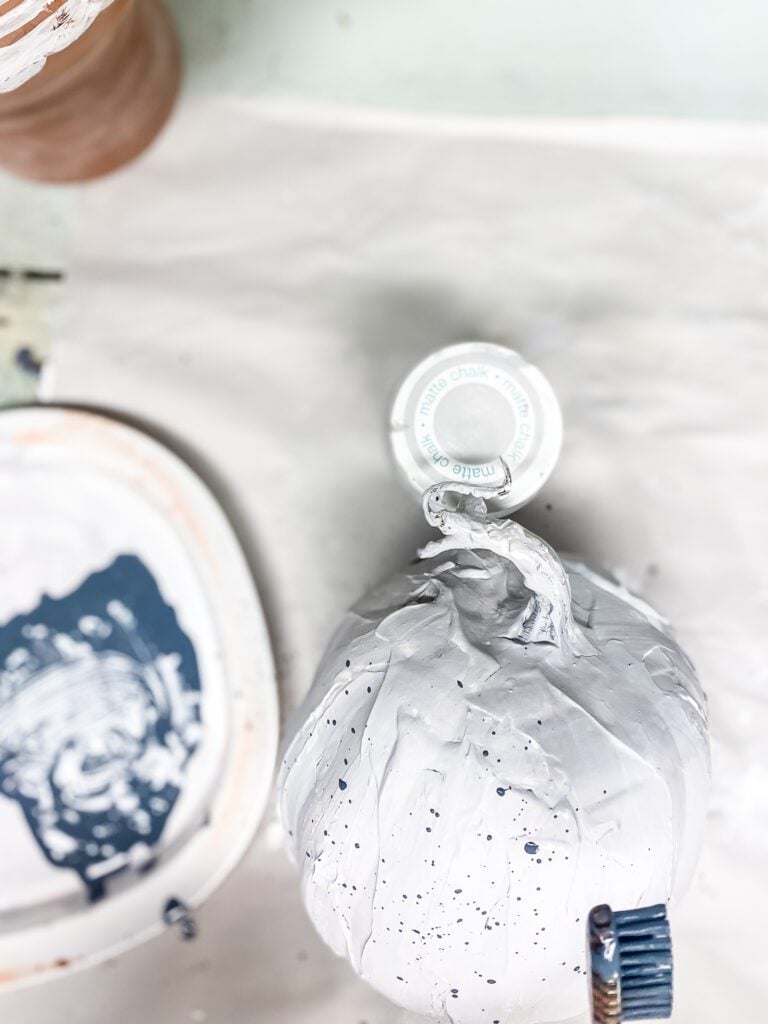 smaking speckles on a pumpkin with paint