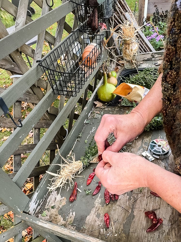 stringing dried chili peppers on wire