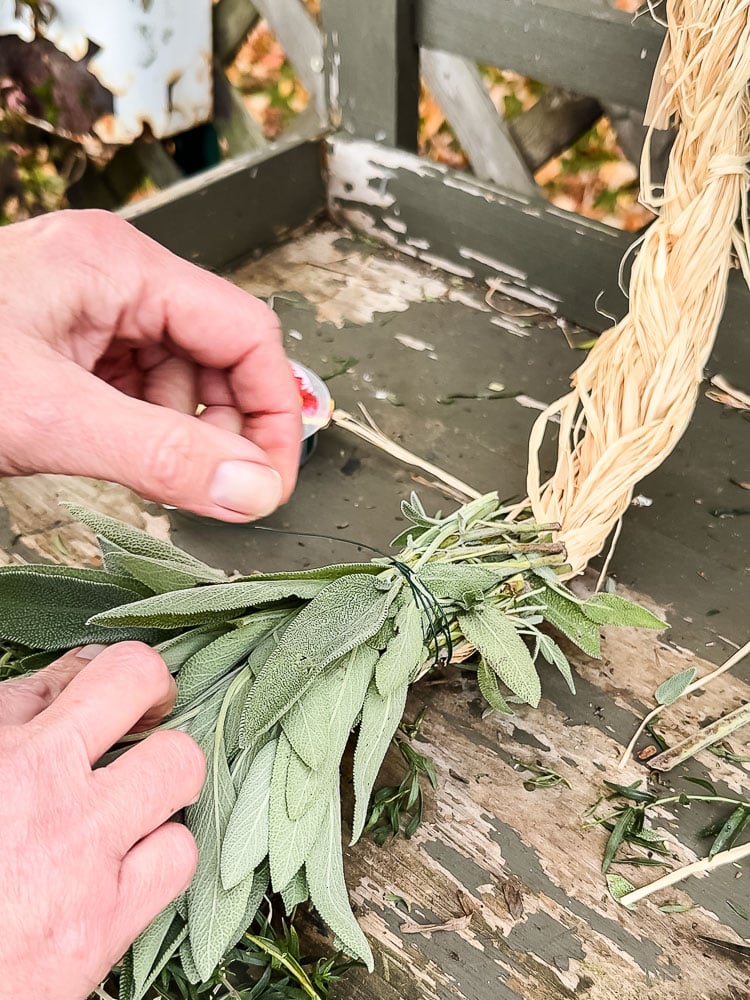 sage being added to a fresh herb swag
