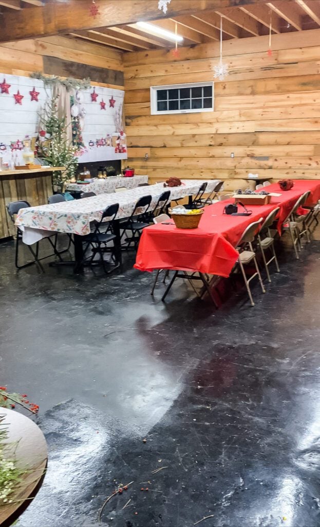 a rustic room with long folding tables and chairs set up