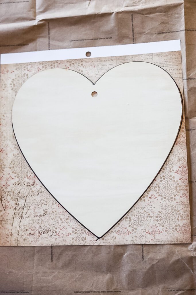 making a heart craft with a wooden heart and scrapbook paper