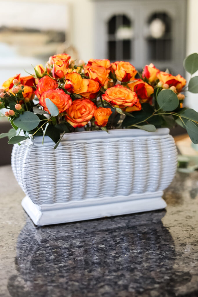 white container with orange roses