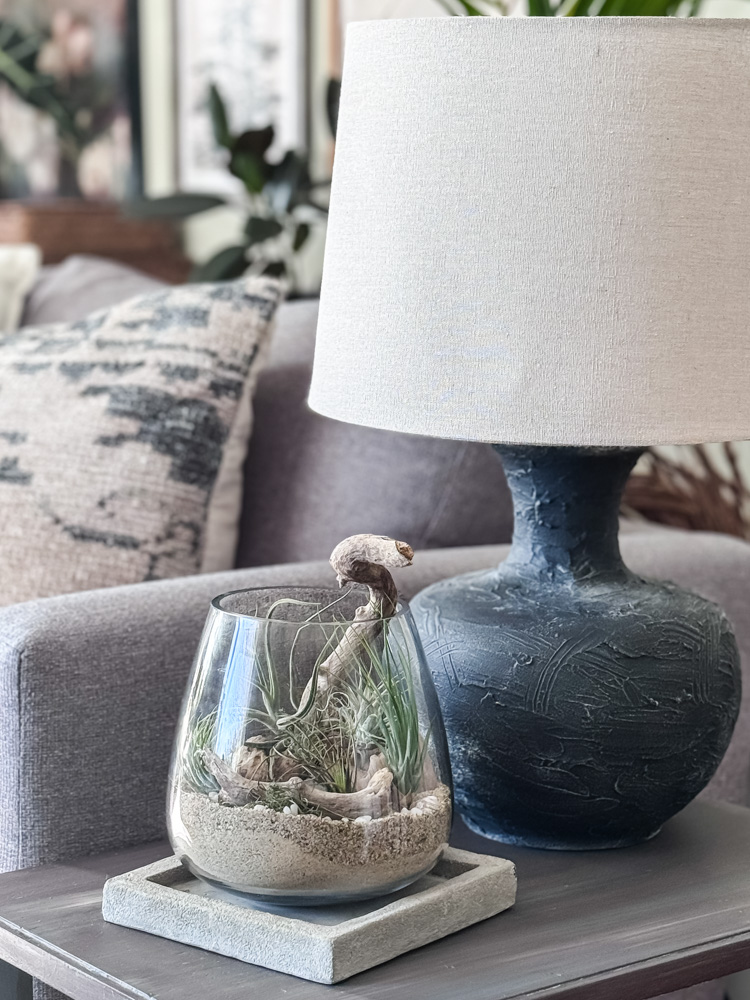 air plant terrarium on end table with black lamp