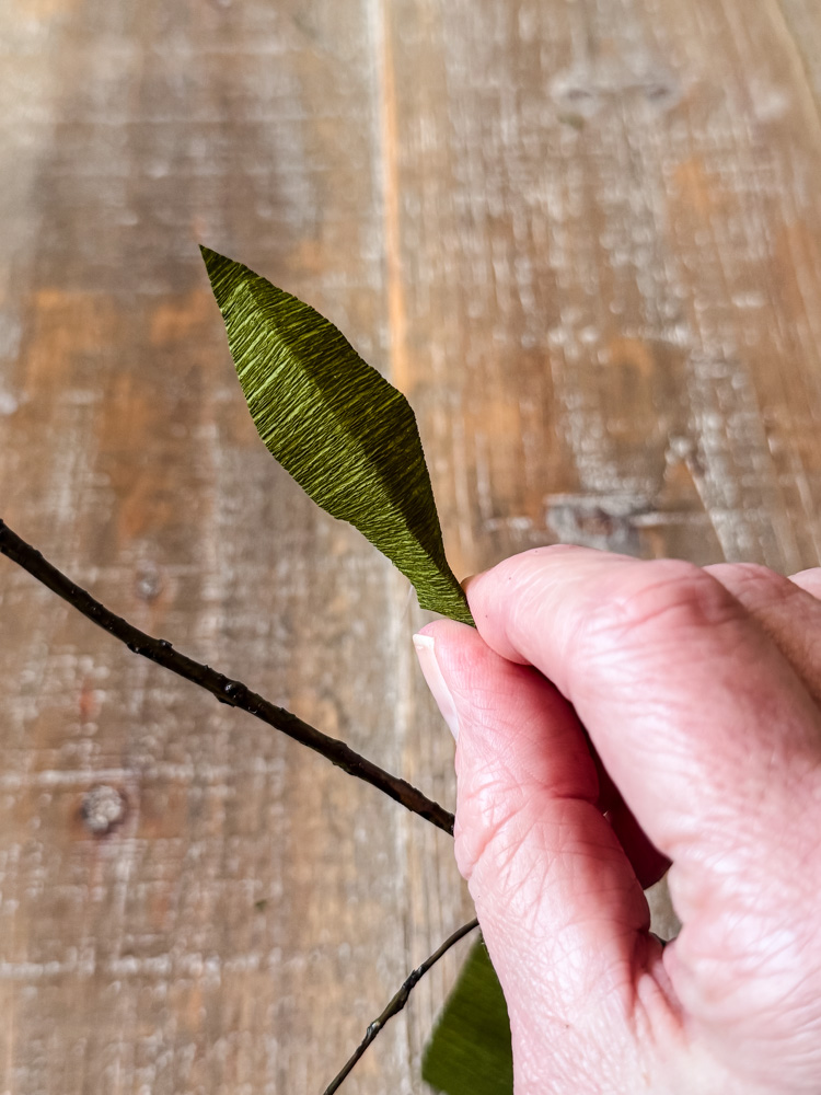 gluing a paper leaf to a faux branch