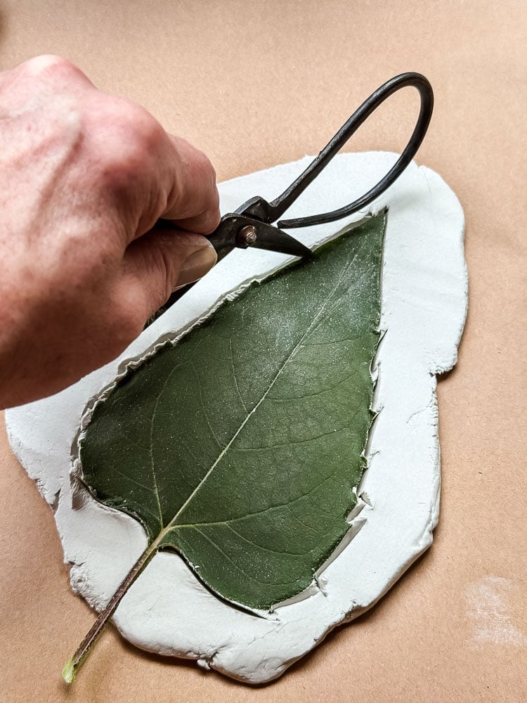 cutting out a leaf shape out of clay