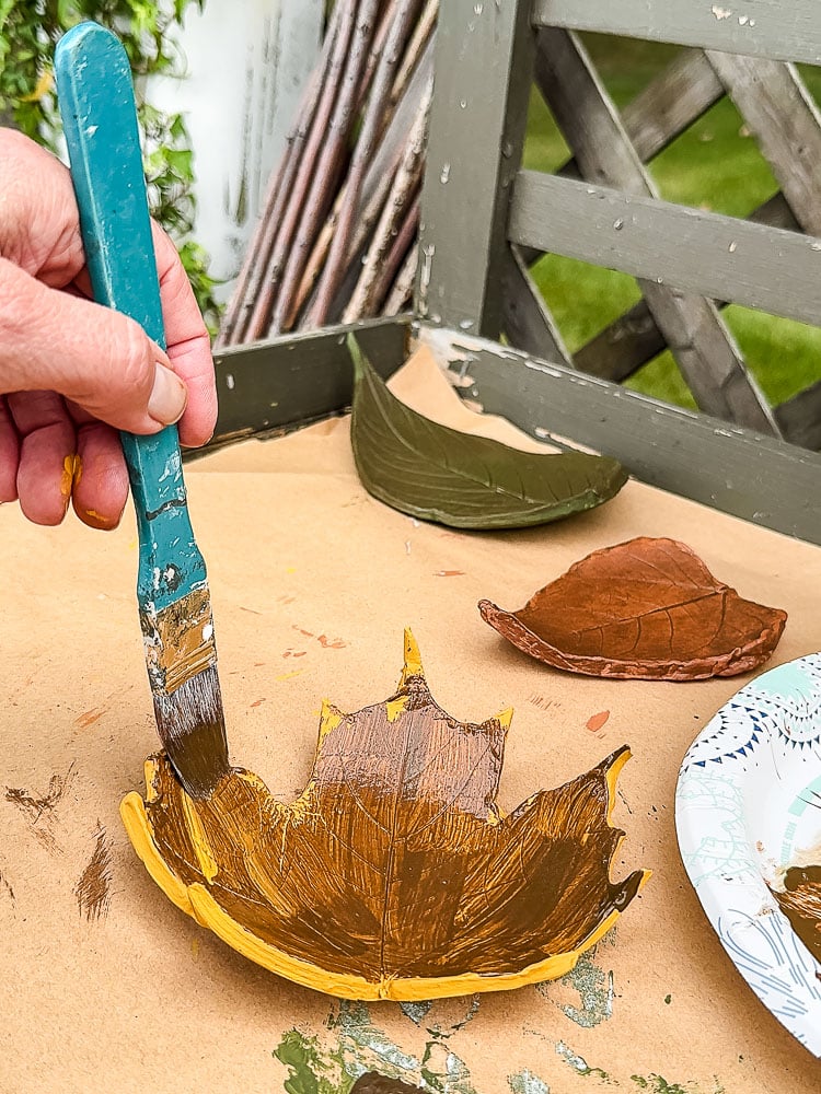 brushing dark wax on clay leaf shape