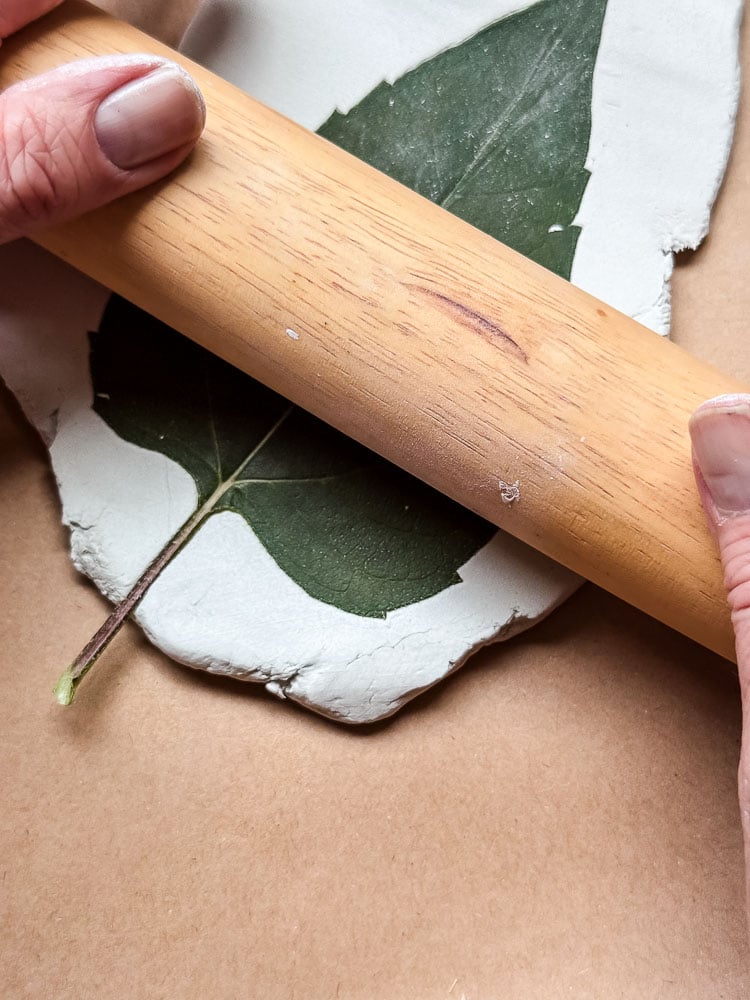 rolling pin going over a leaf on clay