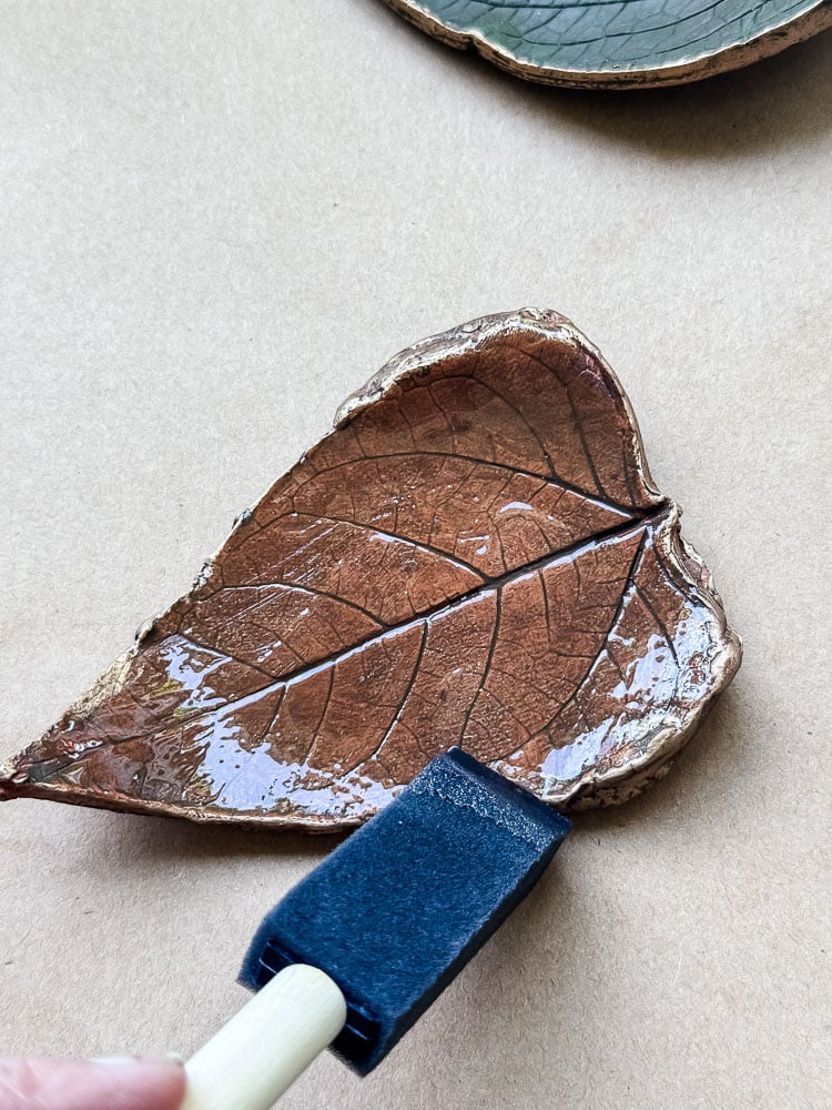 brushing varnish on leaf