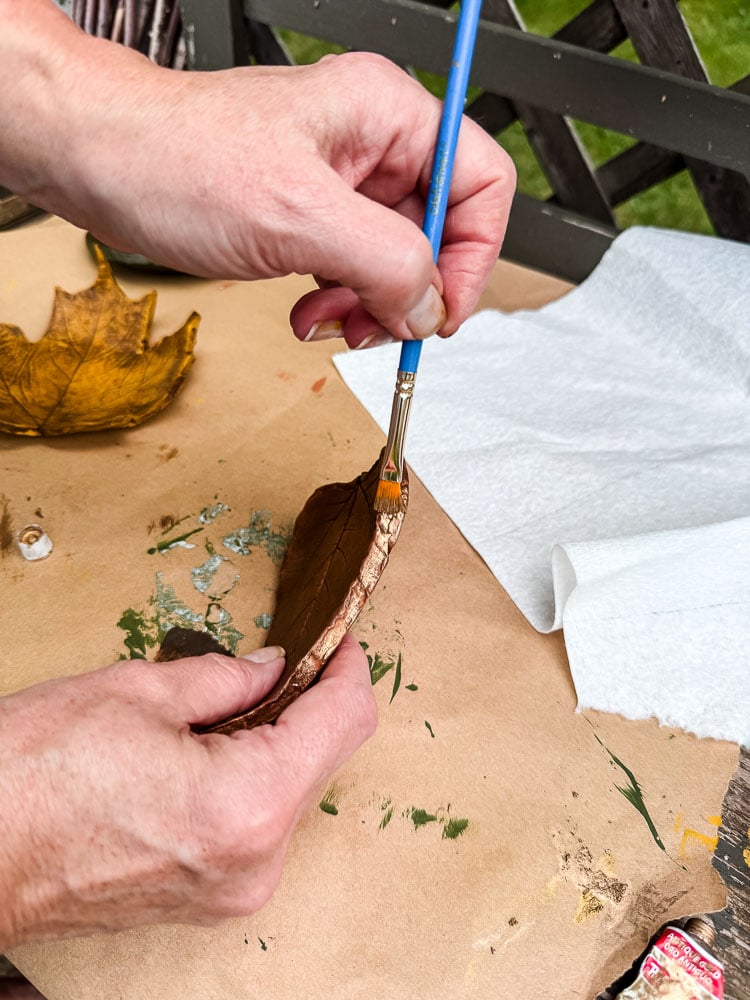 brushing gold wax on edge of clay shape