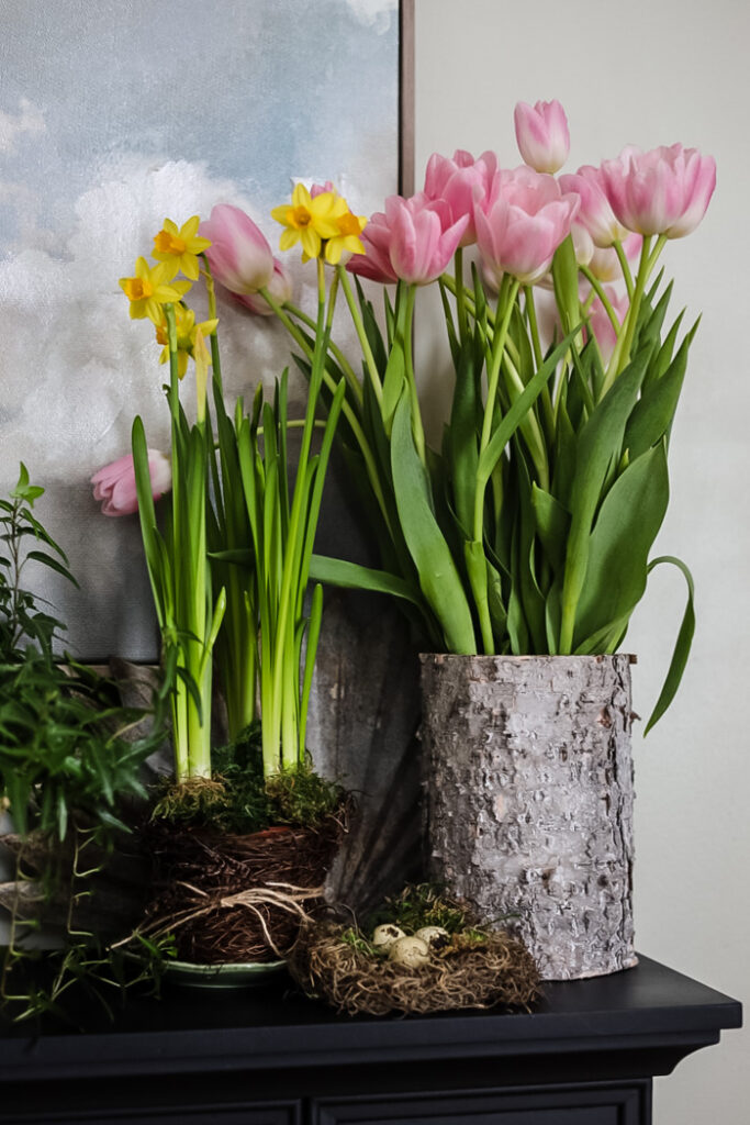 spring display of tulips and daffodils on a mantle