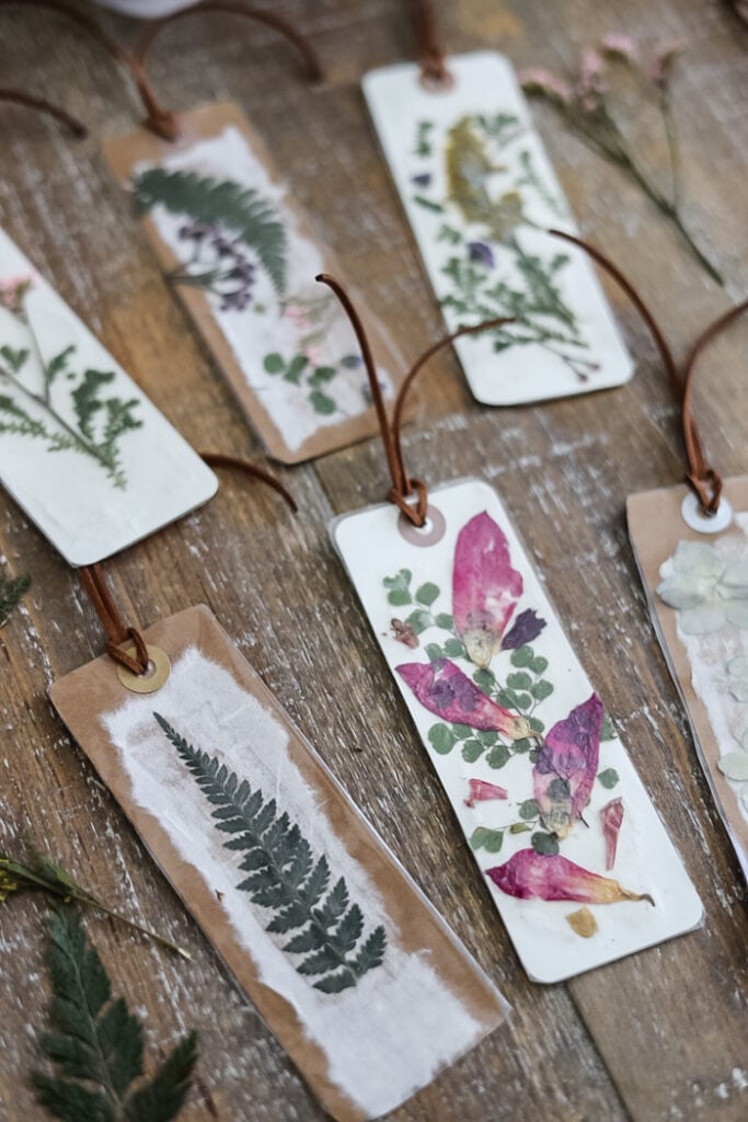 a set of pressed flower bookmarks displayed with dried flowers on a table