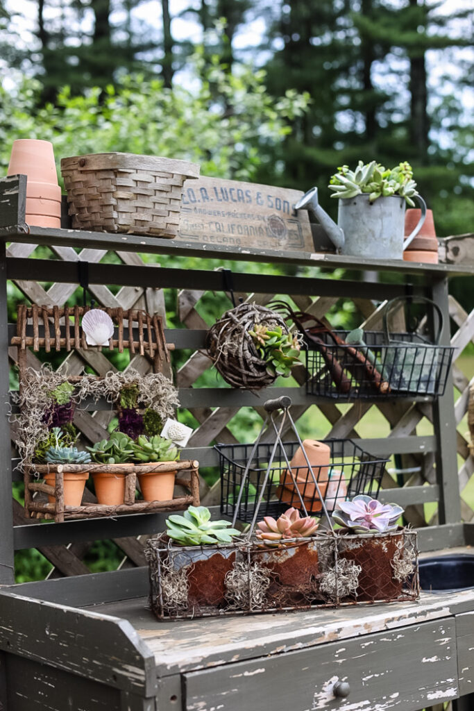 green potting bench filled with vintage finds and succulent planters