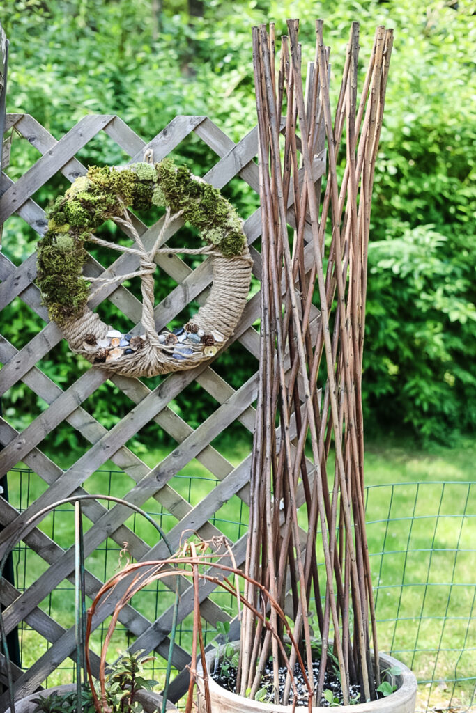 garden view with trellised planters and tree of life wreath