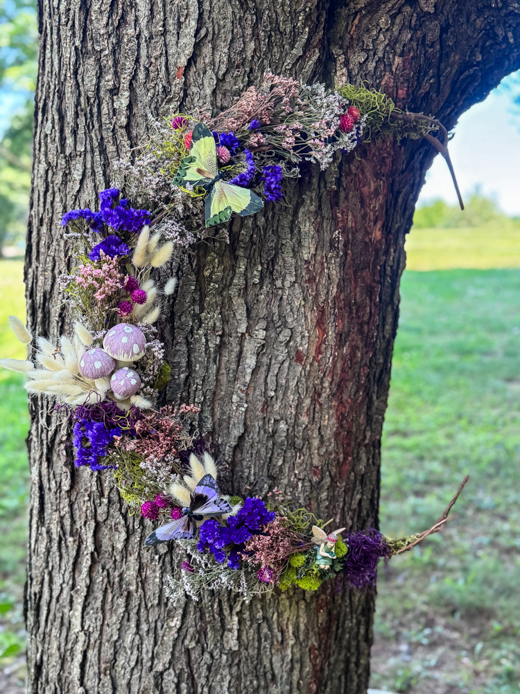 fairy wreath made with dried flowers hanging on a tree