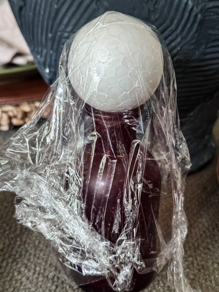 glass bottle with styrofoam ball on top