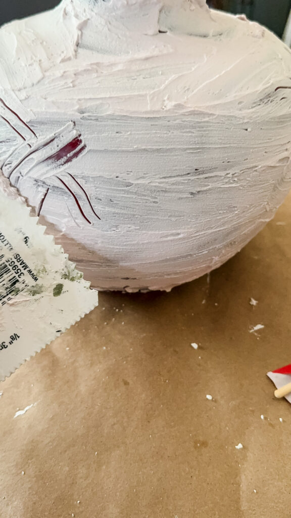 making over a lamp by creating a fake pottery look with joint compound.