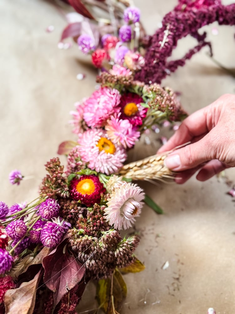 adding wheat to a wreath
