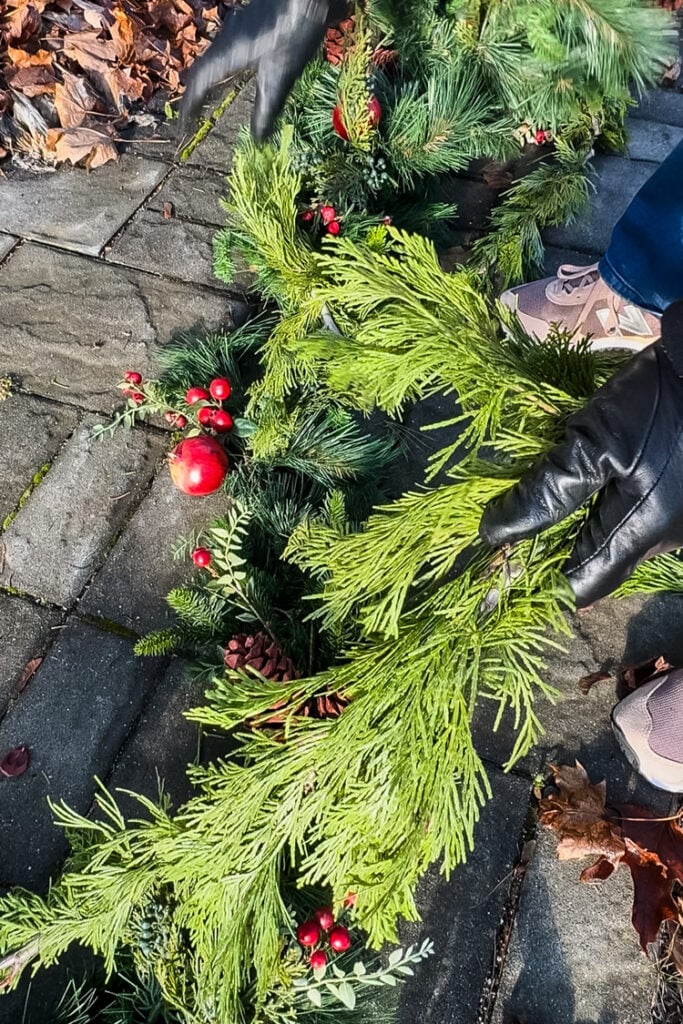 twisting a fresh and artificial winter garland together
