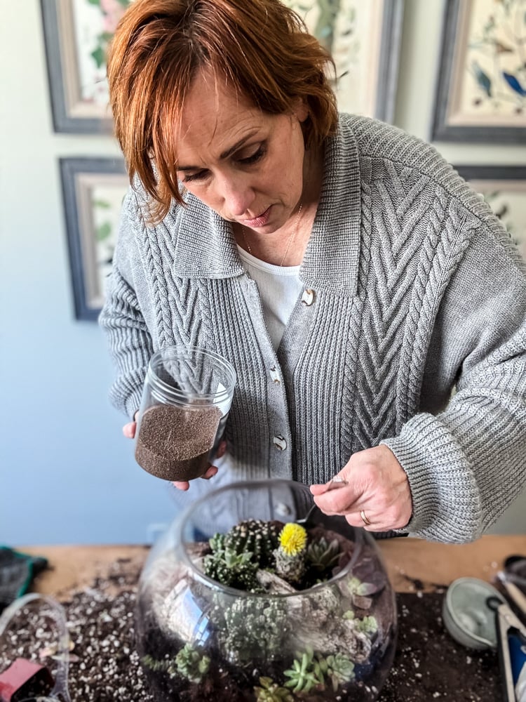 a woman making a terrarium