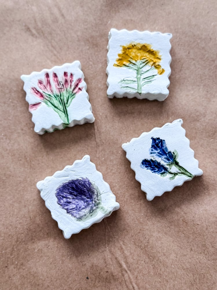 clay magnets with flower impressions that are painted