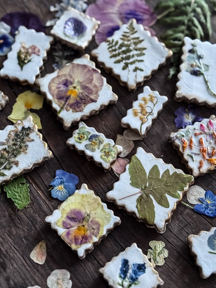 pressed flower magnets styled on top of a bed of pressed flowers