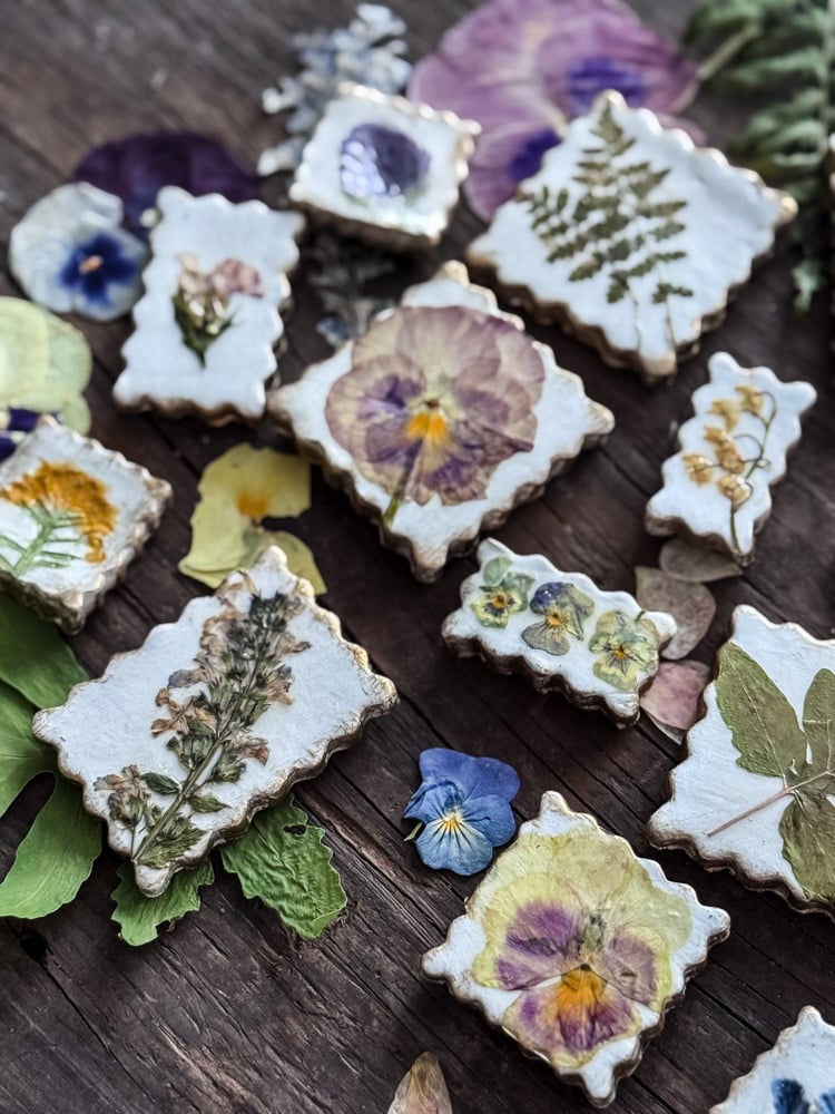 pressed flower magnets styled on top of a bed of pressed flowers