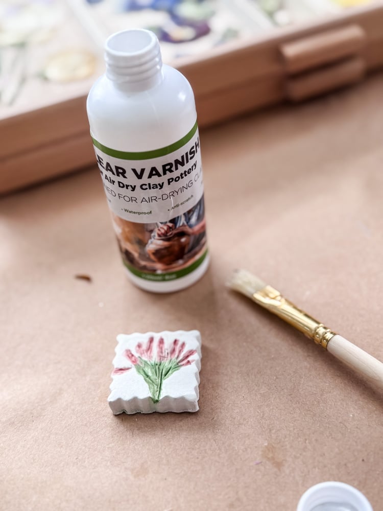 air dry clay varnish and small clay magnet with flower painted on it