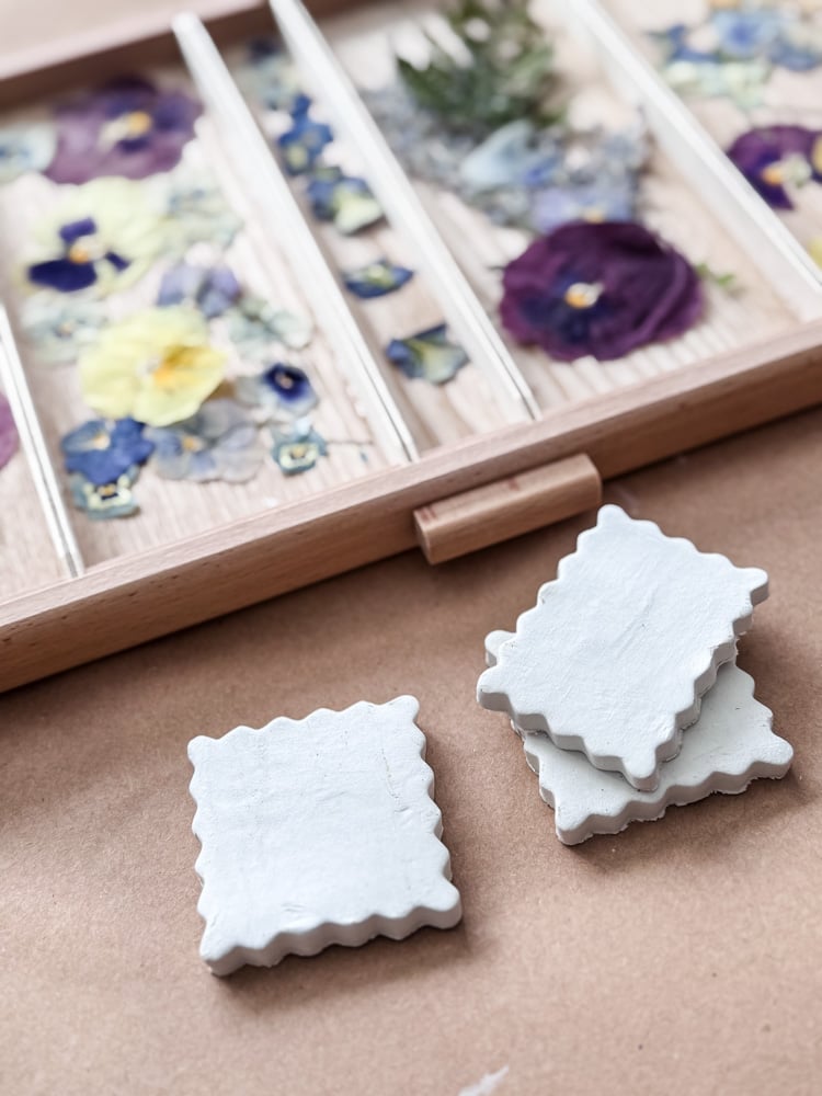 clay magnet project being made with pressed flowrers in a drawer
