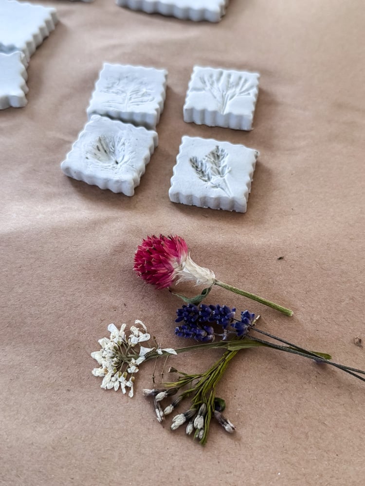 clay shapes with flower imprints and dried flower bundle