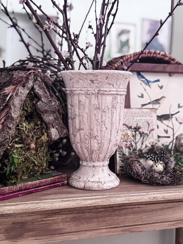 vase of cherry blossoms in vintage vase on table with mirror