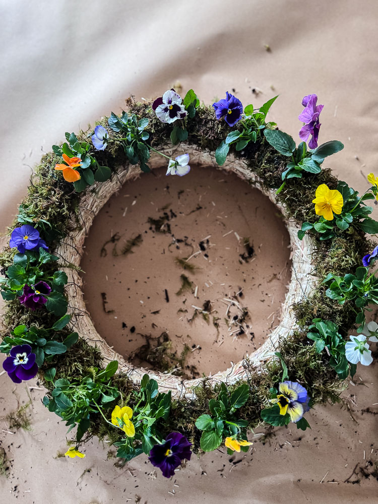 overhead view of a diy pansy wreath on brown paper background