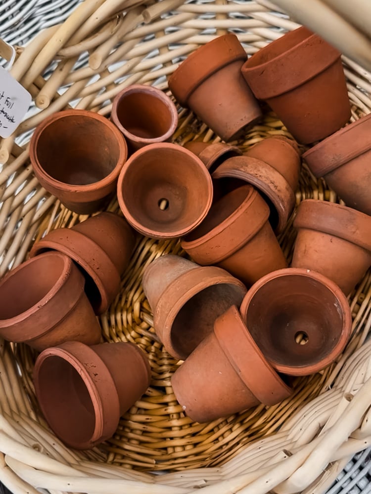 a basket of vintage terracotta pots