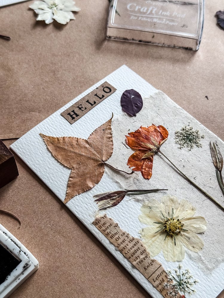 handmade notecard with pressed flowers and 'hello' stamped on it