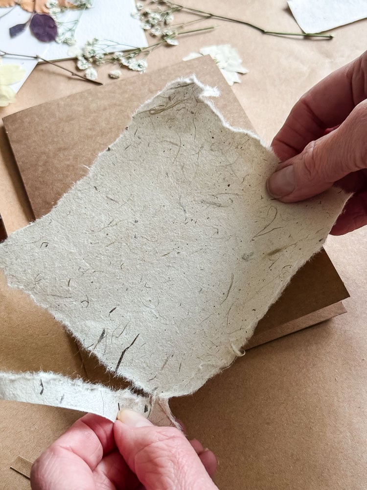 ripping a piece of paper to use on a handmade card