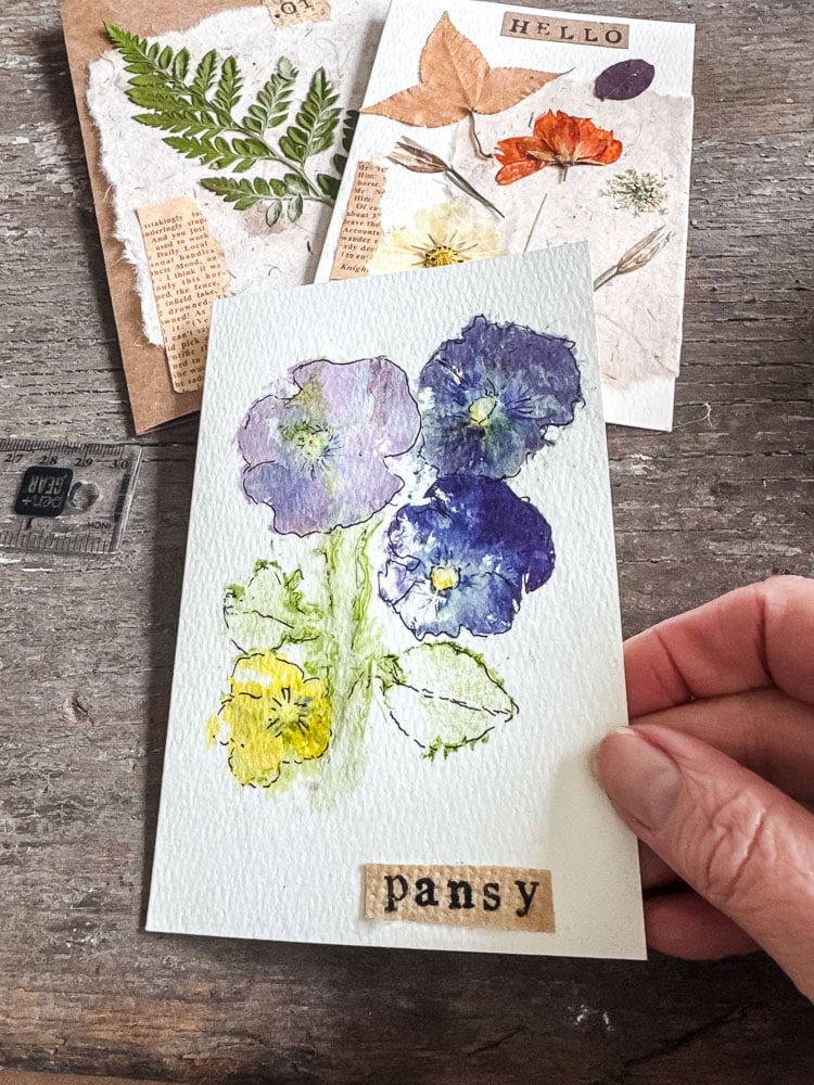 a pansy notecard being held with a woman's hand