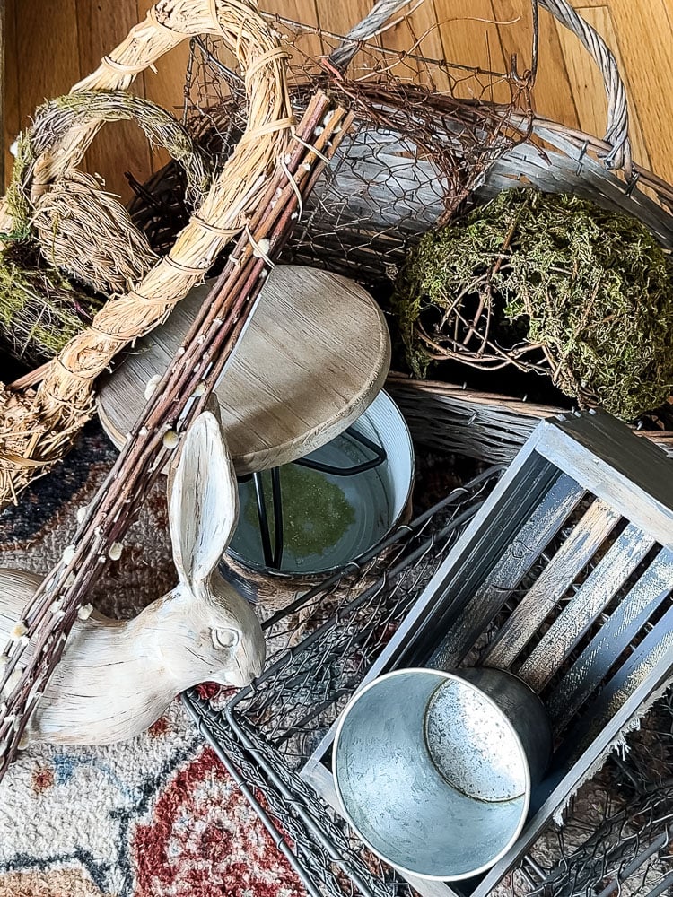 a pile of things to decorate a porch like baskets, statues, and pots