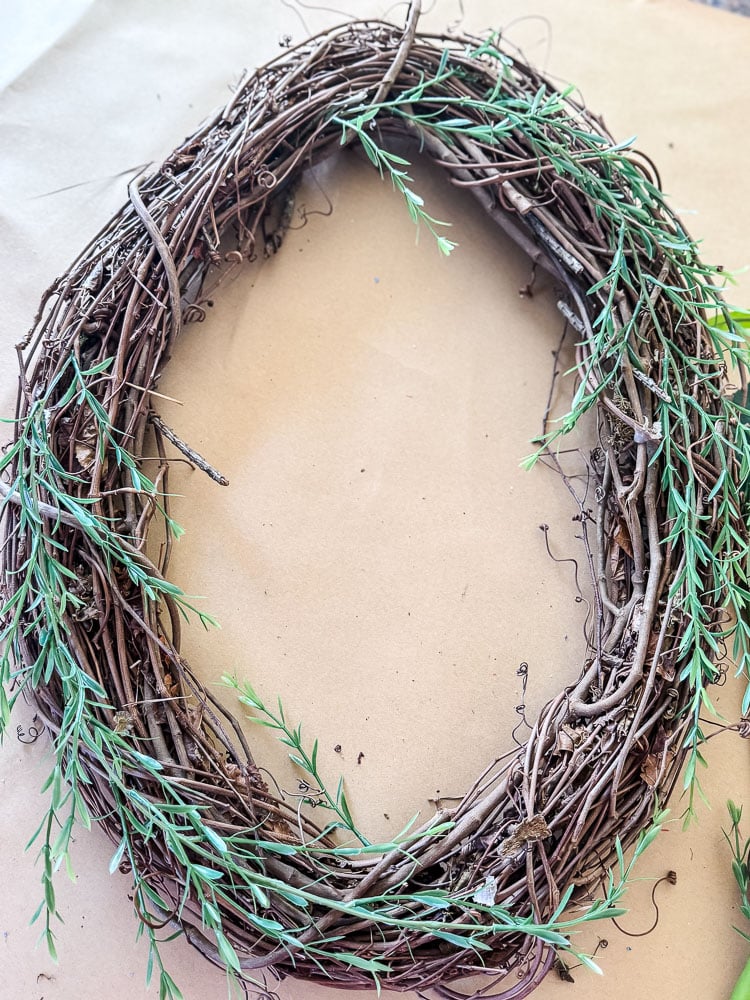 a grapevine wreath with greenery