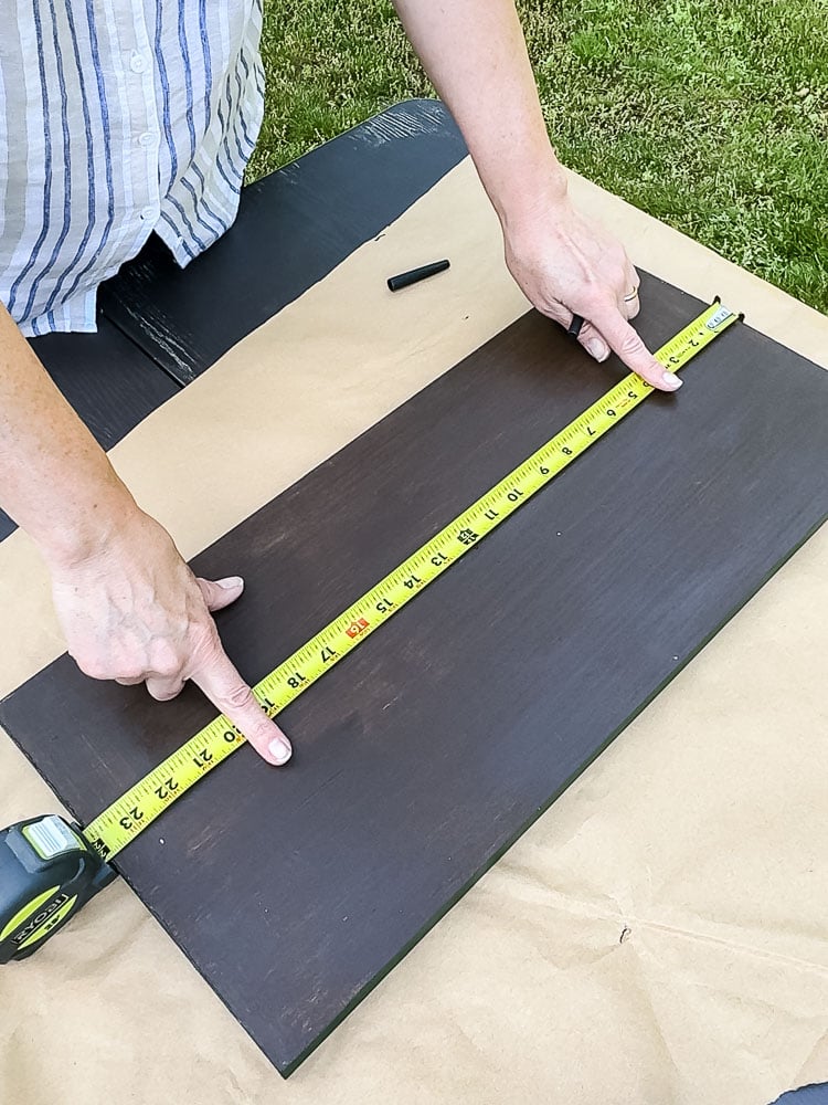 using a tape measure to measure a board