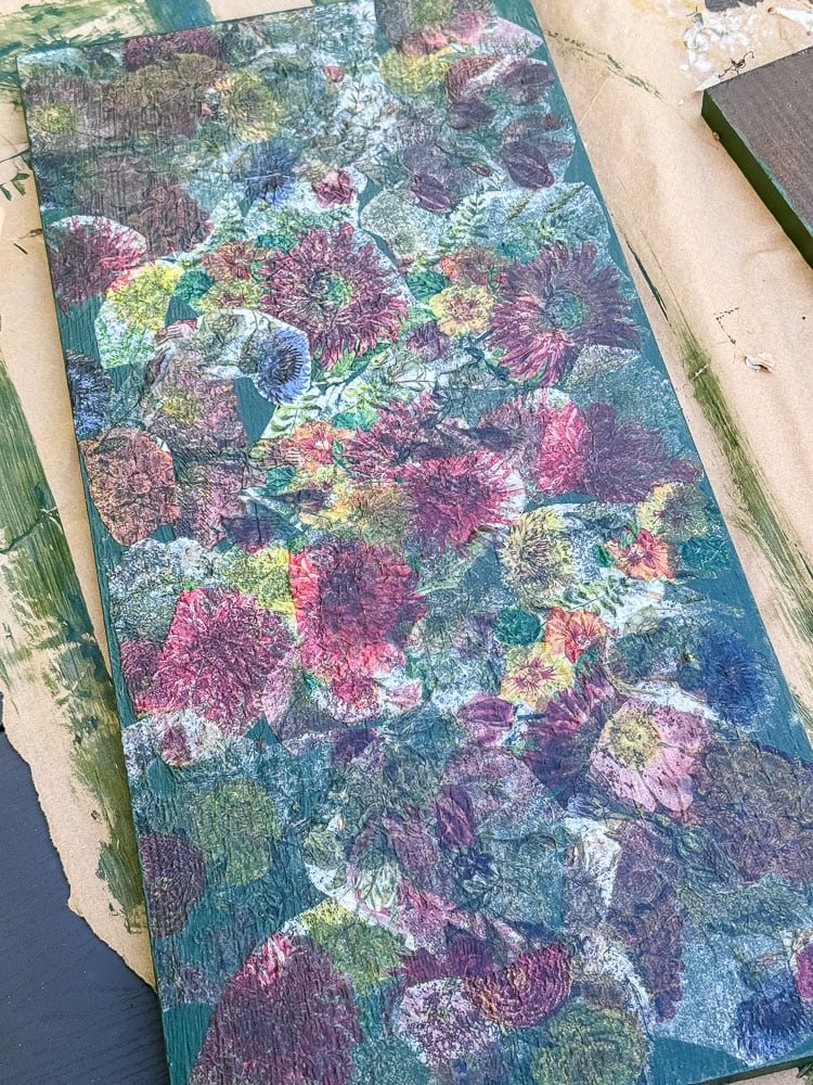 a decoupaged piece of wood that is being used to make a flower press
