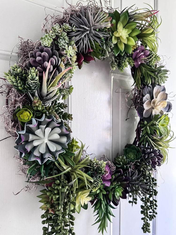artificial succulent wrath hanging on a light blue door