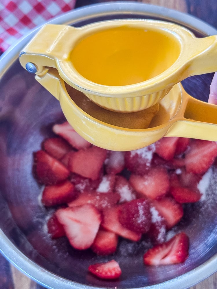 squeezing lemon juice onto strawberries