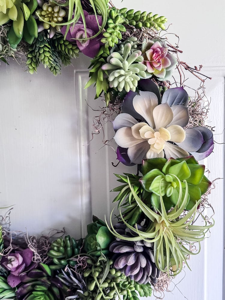 half of a succulent wreath on a door